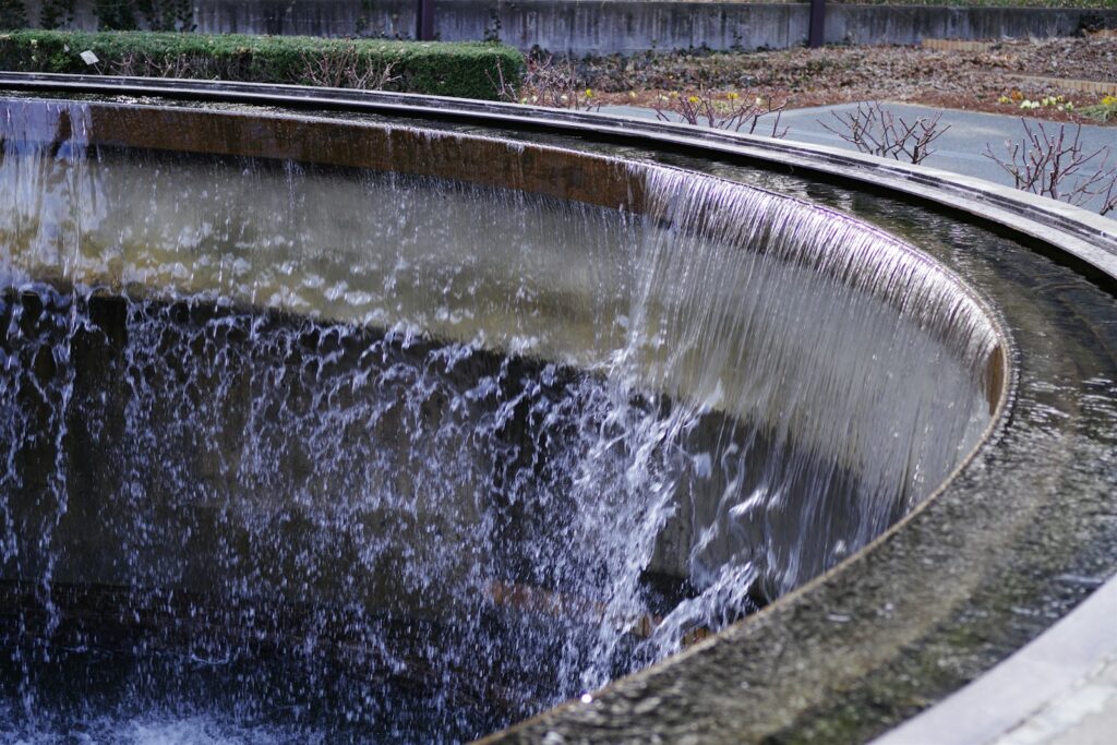 Water cascades over the edge of a fountain.